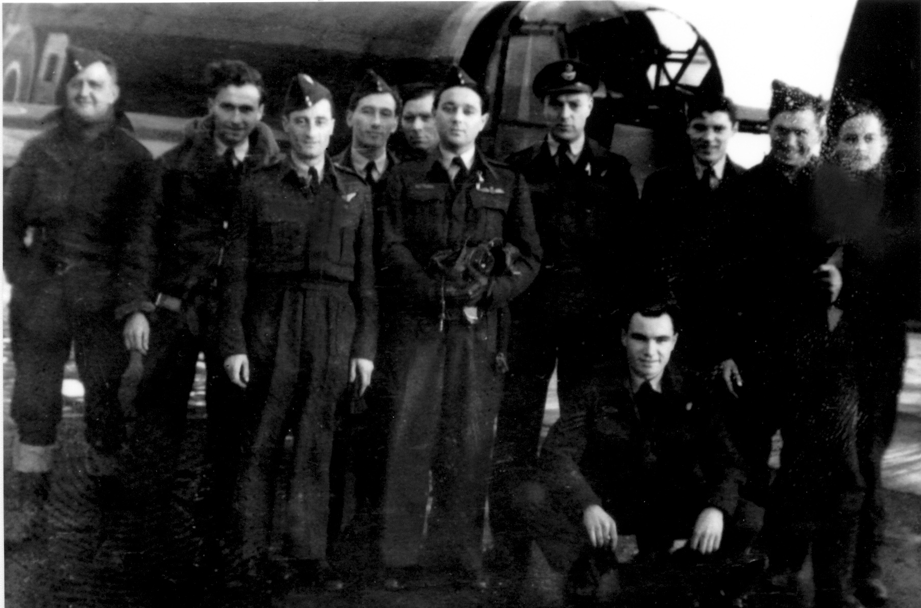 Black and white picture of personnel sitting in front of a Lancaster.